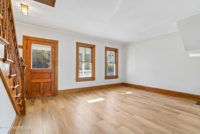 foyer entrance with crown molding and light hardwood / wood-style floors