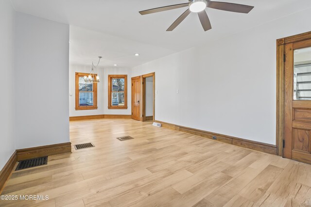 interior space featuring a wealth of natural light, light hardwood / wood-style flooring, and ceiling fan with notable chandelier