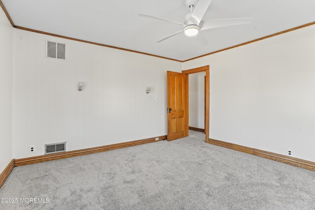 empty room featuring ceiling fan, ornamental molding, and carpet flooring