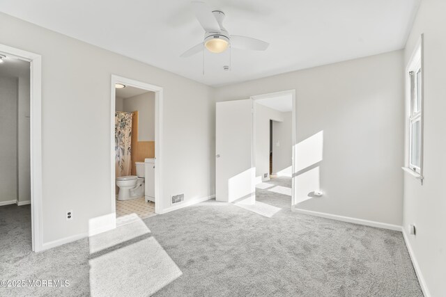 carpeted bedroom with ceiling fan and ensuite bath