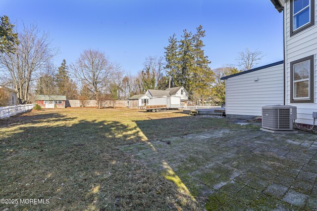 view of yard featuring a shed and central air condition unit