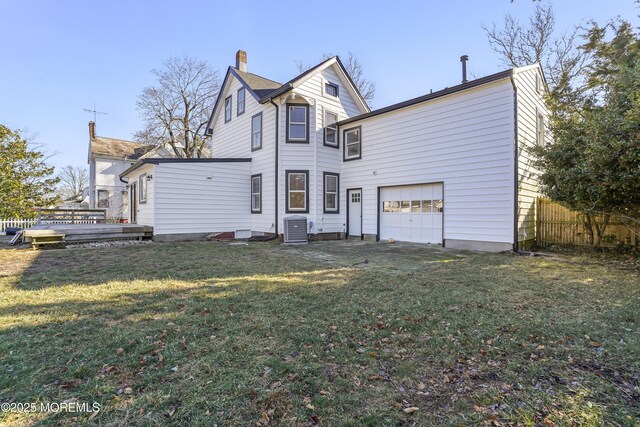 rear view of house featuring a garage, a yard, central AC, and a deck