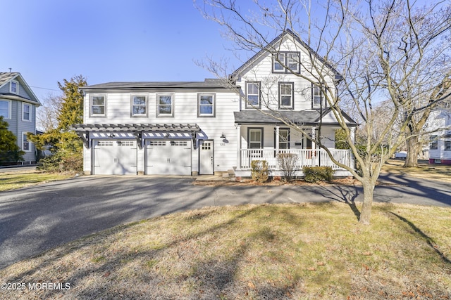 view of front of home with a garage, a front yard, and covered porch