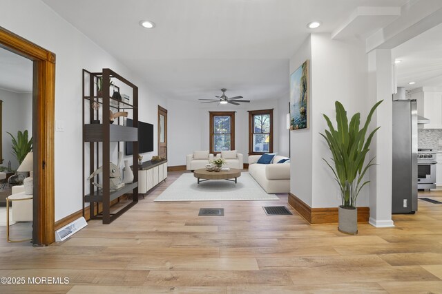 living room with ceiling fan and light wood-type flooring