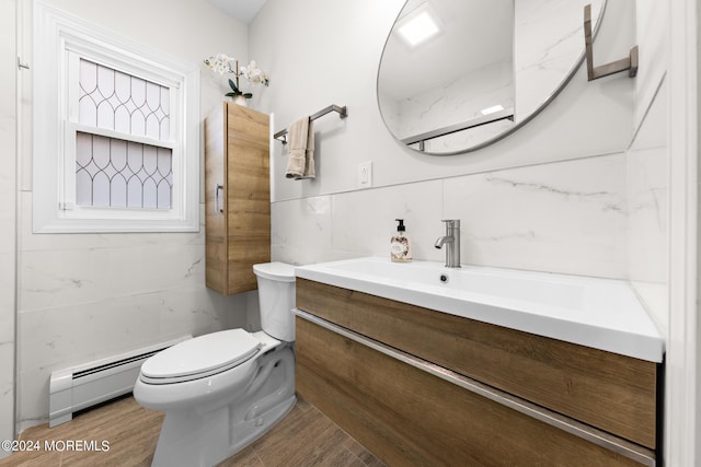 bathroom with tile walls, vanity, a baseboard radiator, and toilet