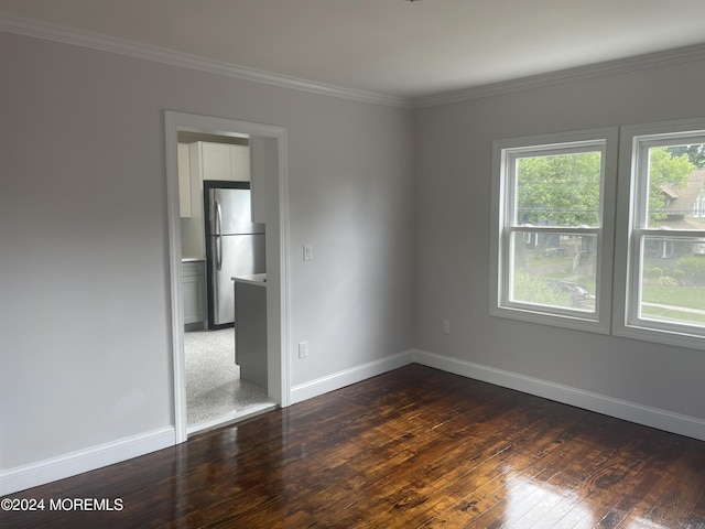 spare room featuring crown molding and dark hardwood / wood-style flooring