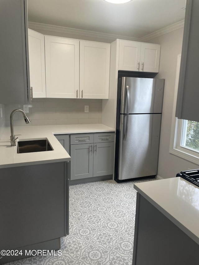 kitchen featuring white cabinetry, sink, gray cabinetry, stainless steel fridge, and crown molding