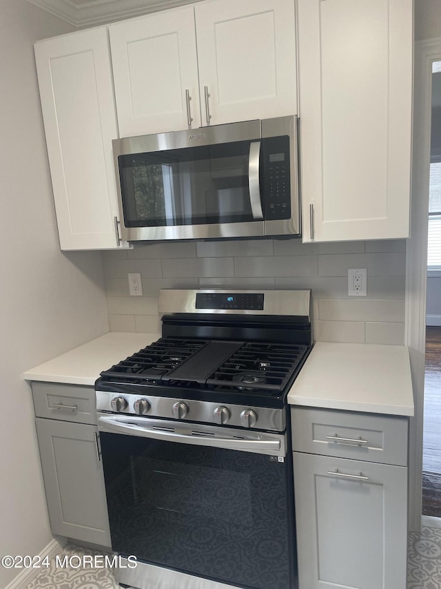 kitchen featuring appliances with stainless steel finishes, white cabinets, and backsplash