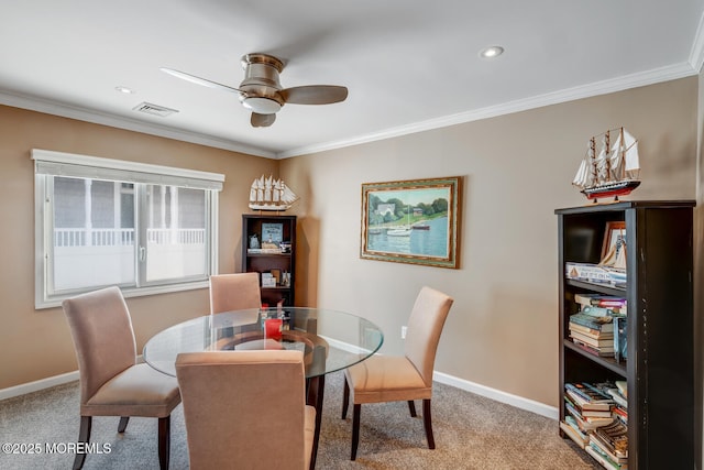 carpeted dining room with ceiling fan and ornamental molding