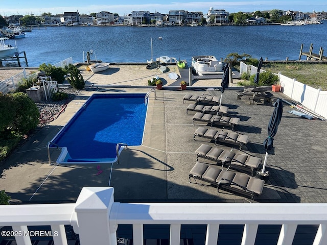 view of swimming pool with a patio area and a water view