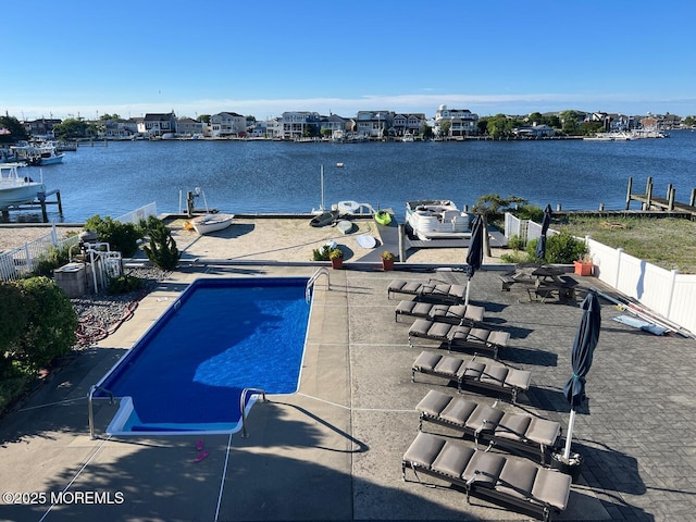 view of swimming pool featuring a water view and a patio area