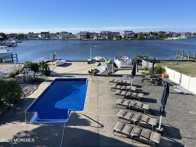 view of pool featuring a water view and a patio