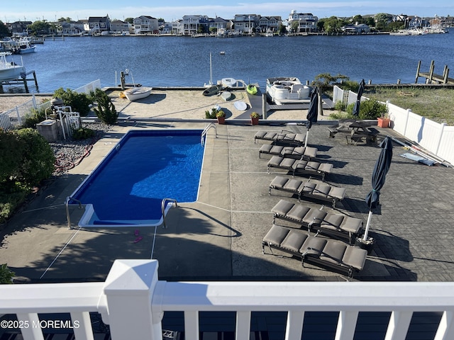 view of swimming pool with a patio and a water view