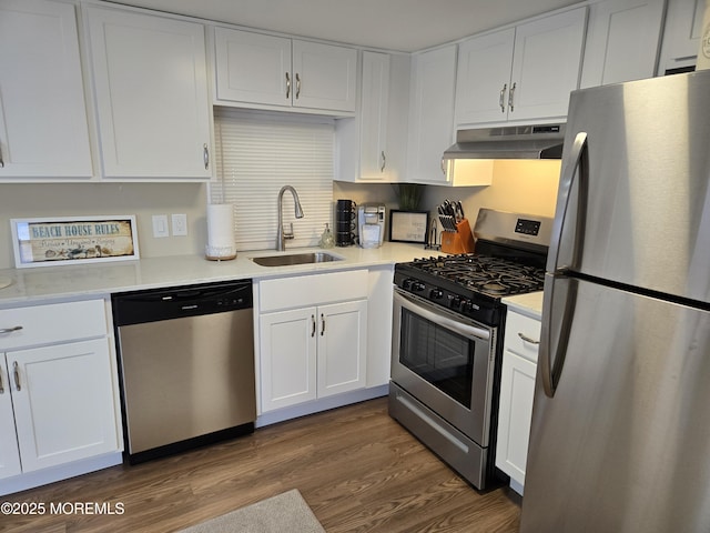 kitchen with appliances with stainless steel finishes, sink, white cabinets, and dark hardwood / wood-style flooring