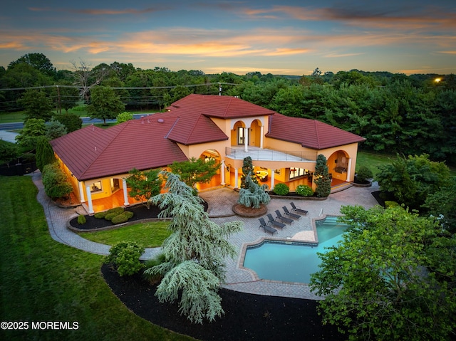 1548 N Bay Ave, Toms River, NJ 08753 - back of house at dusk with stucco siding, a tiled roof, a yard, an outdoor pool, and a patio