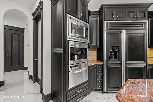 1548 N Bay Ave, Toms River, NJ 08753 - kitchen with light marble finish flooring, built in appliances, arched walkways, and dark cabinets