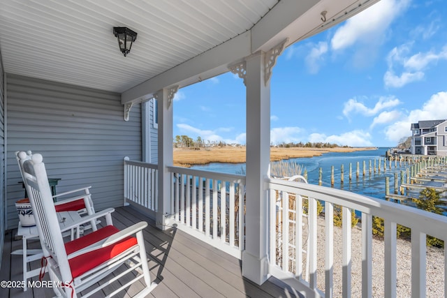 wooden deck featuring a dock and a water view