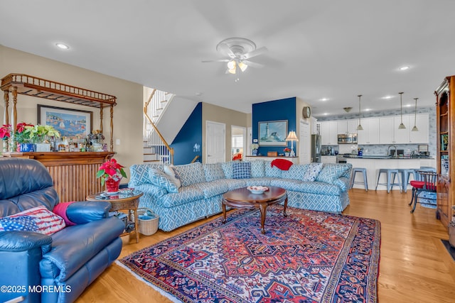 living room with ceiling fan and light hardwood / wood-style floors