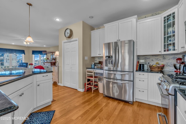 kitchen with white cabinetry, decorative light fixtures, light hardwood / wood-style flooring, and stainless steel appliances