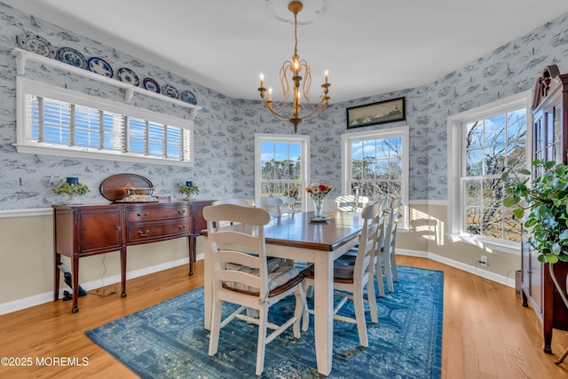 dining area with a notable chandelier and light hardwood / wood-style flooring