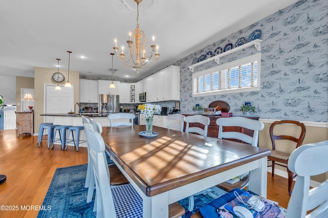 dining room featuring a notable chandelier and light wood-type flooring