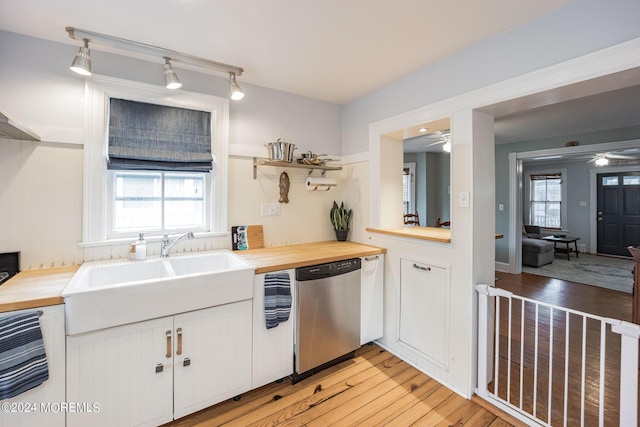 kitchen featuring wood counters, sink, white cabinetry, and dishwasher