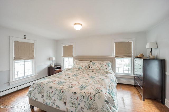 bedroom featuring baseboard heating and light wood-type flooring