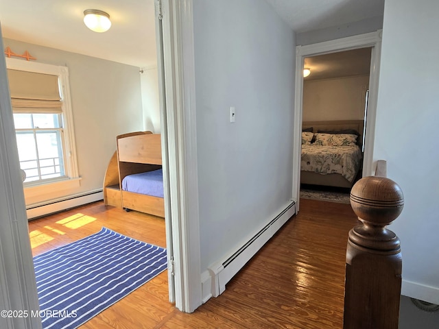 hallway with baseboard heating and dark hardwood / wood-style floors