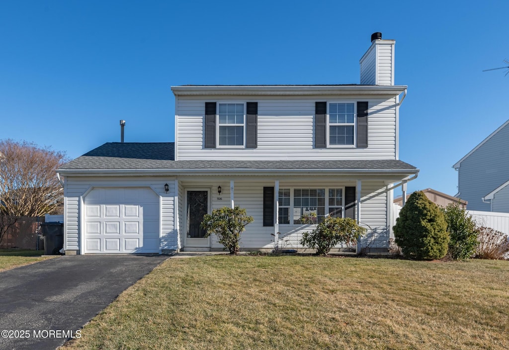 view of front property with a garage, a front yard, and covered porch