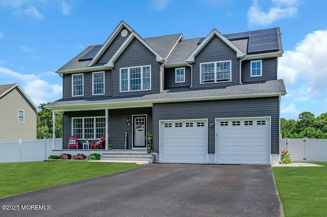 craftsman-style home featuring a porch, a garage, a front lawn, and solar panels