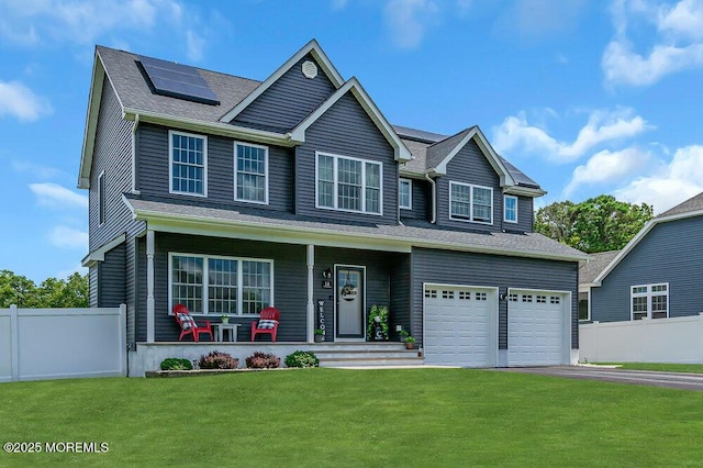 view of front of house with a porch, a garage, a front yard, and solar panels