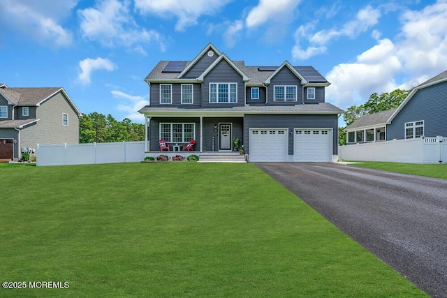 view of front of house featuring a garage, a front yard, solar panels, and a porch