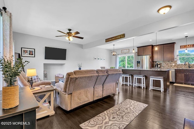 living room featuring ceiling fan, dark hardwood / wood-style flooring, and sink