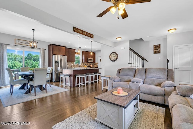 living room featuring ceiling fan and dark hardwood / wood-style floors