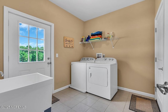 laundry area featuring light tile patterned flooring, separate washer and dryer, and sink