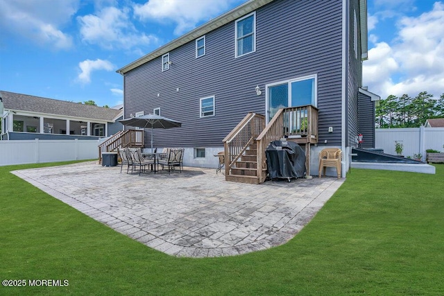 rear view of house featuring a lawn and a patio