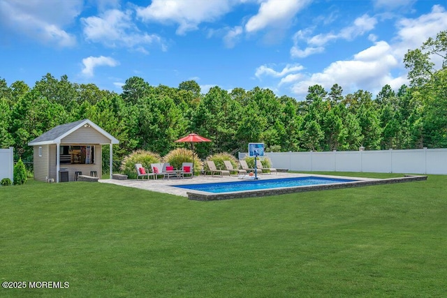 view of swimming pool with an outbuilding, a patio, and a lawn