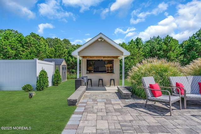 view of patio featuring a bar and a storage unit