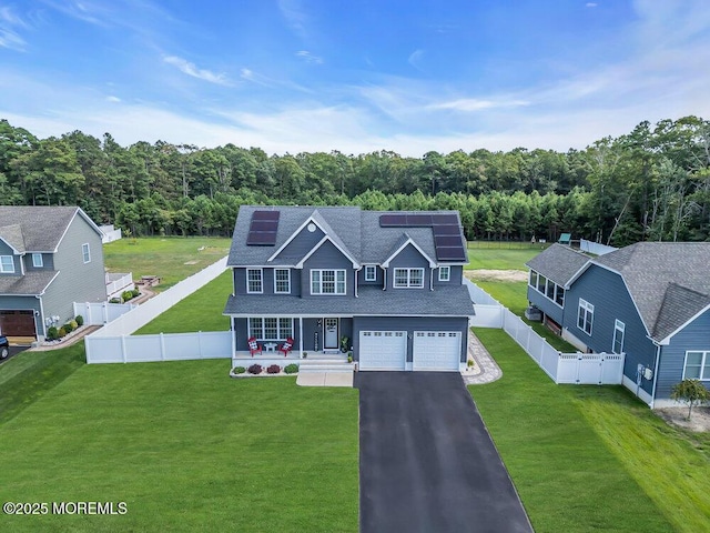 view of front facade featuring a garage, covered porch, a front yard, and solar panels