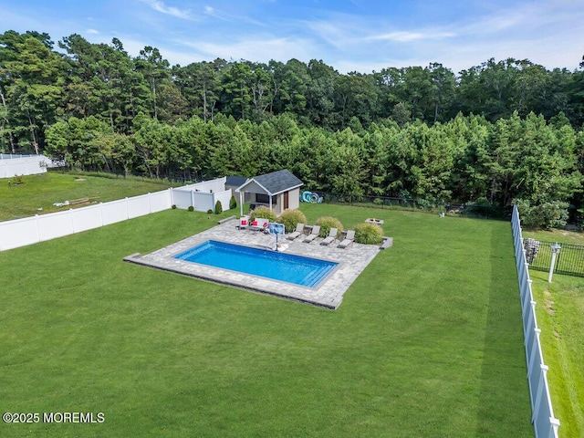 view of pool with a patio area, a lawn, and a storage unit