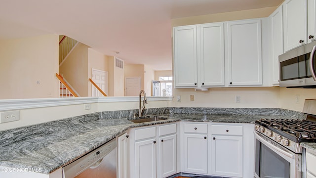 kitchen featuring stainless steel appliances, white cabinetry, and sink