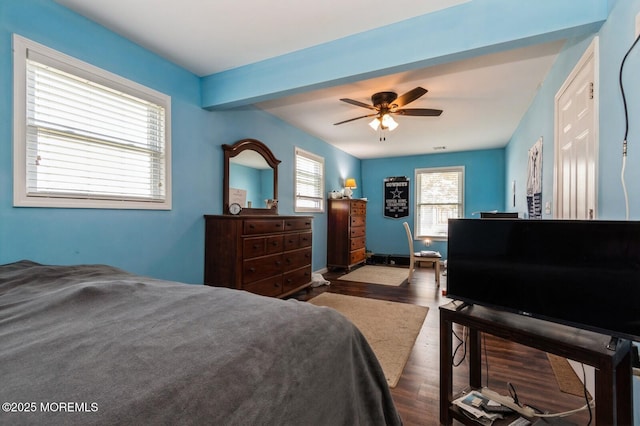 bedroom featuring beamed ceiling, dark wood-type flooring, and ceiling fan