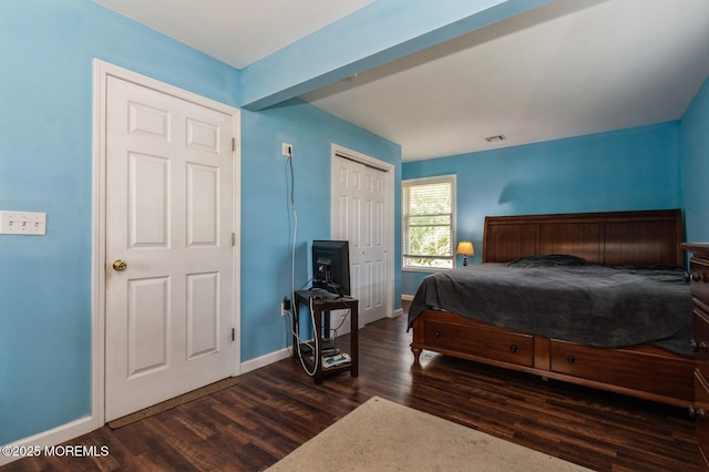 bedroom with dark wood-type flooring and a closet