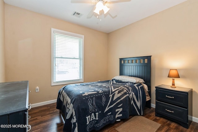 bedroom with dark hardwood / wood-style flooring and ceiling fan