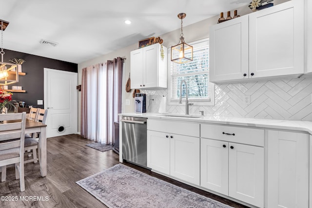 kitchen featuring sink, dishwasher, dark hardwood / wood-style floors, white cabinets, and decorative light fixtures