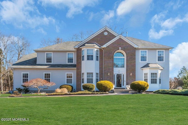 view of front of home featuring brick siding and a front lawn