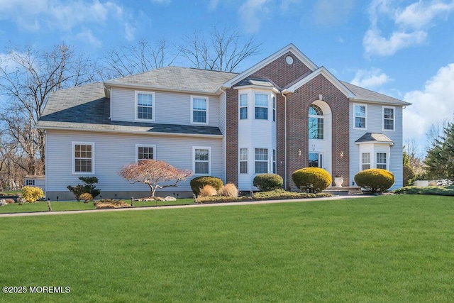 view of front facade featuring a front yard and brick siding