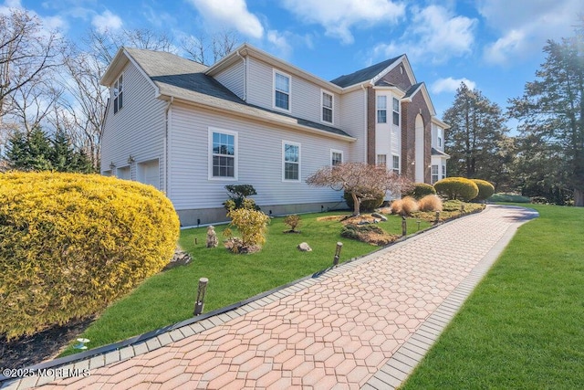 view of side of property with a lawn and an attached garage