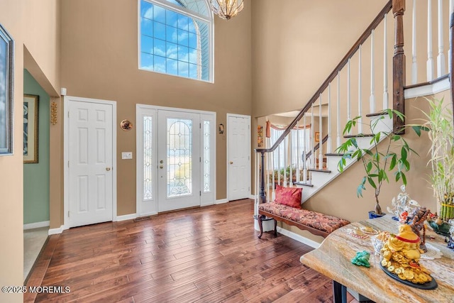 foyer entrance featuring plenty of natural light, stairs, and dark wood-type flooring