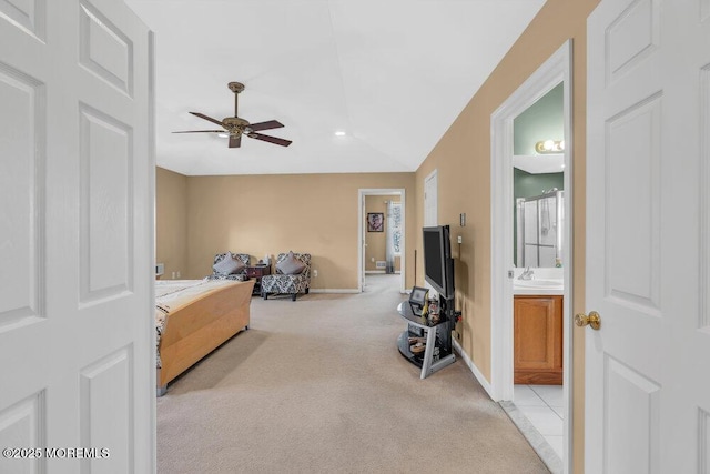 bedroom with baseboards, connected bathroom, light colored carpet, lofted ceiling, and a sink